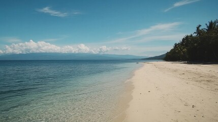 Fototapeta premium Serene tropical beach with white sand, clear turquoise water, and lush green vegetation under a vibrant blue sky.