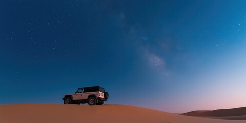 Fototapeta premium A parked expedition vehicle atop a towering sand dune under a mesmerizing night sky