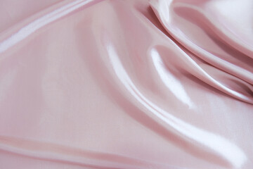Wavy fabric texture background of pink satin. Close-up satin fabric texture. Abstract background of smooth texture, pastel, pink cloth, silk curve, wedding, luxury, vivid style for fashion backdrop