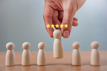 Leadership and Career Growth in HR Recruitment. A hand picks a wooden figure with five glowing stars. excellence, recruitment, leadership, employee selection, recognition, and high performance.