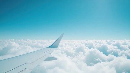 Fototapeta premium Airplane wing above clouds against clear sky, perfect travel and adventure concept