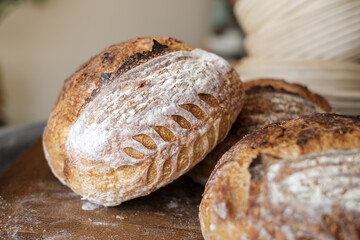 Artisan Batard Sourdough healthy Bread with leaf scoring. Open crumb high hydration Sourdough bread set on white table.
