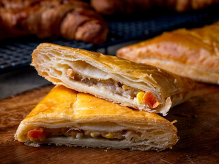 Fresh Baked puff pastry pie with filling on wooden cafe table