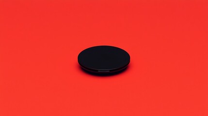 Black Circular Object on Red Background