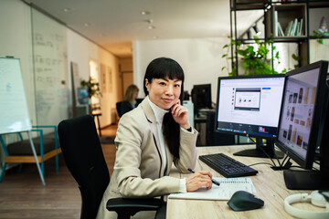 Smiling Asian businesswoman working in modern office