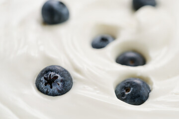 Closeup of fresh blueberries in white yogurt