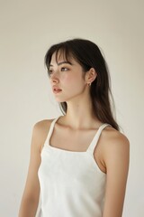 Chubby jaoanese woman wearing a white tank top with a square neckline background portrait female.