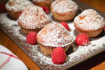 Fresh cupcake sprinkled with powdered sugar. Homemade cupcakes with raspberries. Photo