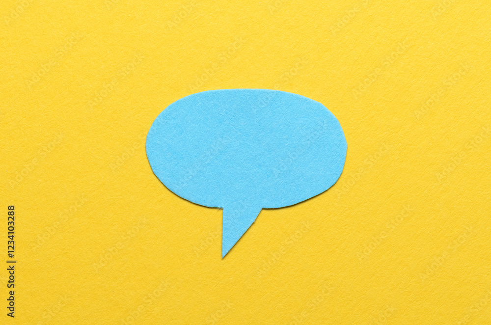 Aufkleber blue cut out blank paper speech bubble of round shape with copy space for text on yellow background,