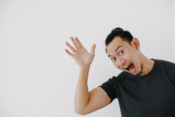 Cheerful man waving hand to say hi in black t-shirt isolate on white.
