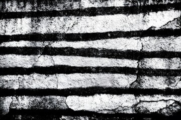 High-contrast black and white image of a distressed, weathered surface with prominent horizontal scratches. The texture is grainy and tactile, with a worn-out appearance.
