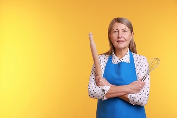 Woman with rolling pin and whisk on yellow background. Space for text