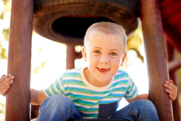 Climbing, growth and portrait of boy at playground, having fun in nature for activity, games or...