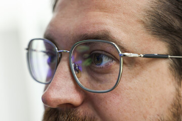 Man wearing stylish glasses on blurred background, closeup