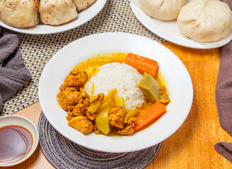 Nanyang Chicken Curry Rice and Steamed Buns with sauce served in plate isolated napkin side view of taiwan dim sum food