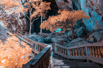 Infrared effect, a cave entrance surrounded by vivid, colorful foliage