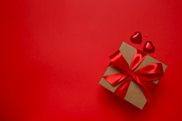 Gift box with red hearts on color background