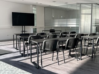 Modern, bright office with black chairs and a large monitor for presentations