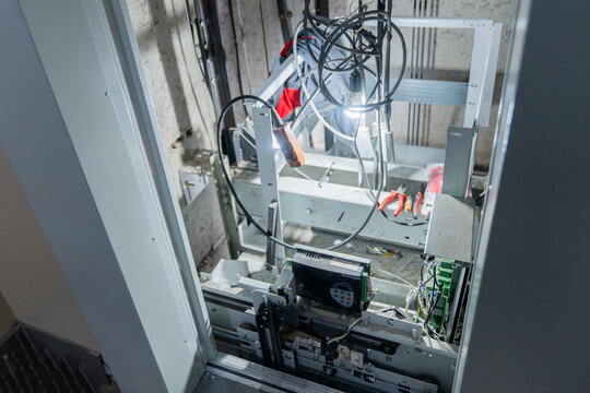 This is an interior view of an elevator shaft with essential mechanical parts and wiring