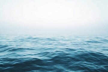 Obraz premium Serene view of gentle ocean waves extending to the horizon, blending into a soft and calm atmospheric background