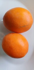 Two oranges on white background, closeup, vertical photo