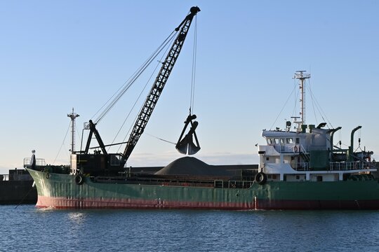 A scene of dredging work at the port. The purpose of dredging work is to scoop up sediment from the seabed with a dredger ship to ensure safe navigation of ships.