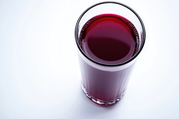 A clear glass filled with a deep red liquid on a white background