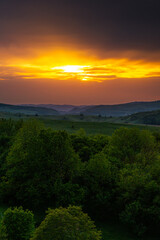 Aerial view of the lush green hills of Transylvania during sunset, showcasing the natural beauty and untouched landscapes of this Romanian region. Travel to Romania.