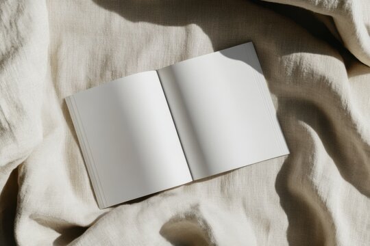A blank landscape magazine mockup rests open on a soft, textured fabric background, illuminated by gentle natural light, enhancing the inviting and artistic essence of the setting