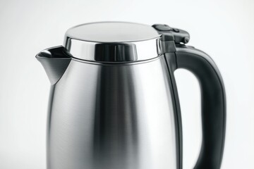 A close-up shot of a stainless steel kettle with a black handle, great for food photography or still life images