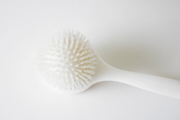 A detailed view of a brush with bristles and handle, placed on a clean white surface