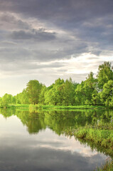 Lake with trees in the background and a cloudy sky