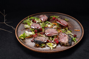 Grilled beef Striploin steak sliced on the grill and a close-up tomato. Copy space