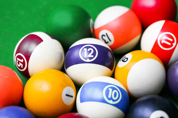Pool ball game on a green billiard table. Playing snooker and billiards with cue. Numbered ball background. Fun sports environment. Violet ball number twelve. Entertainment backdrop.