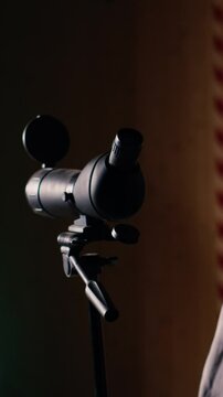 Vertical video Friends in firing range doing recreational shooting, using magnifying lens to see targets. People training with handguns, sharpening skills, zooming to check points scored on bullseyes