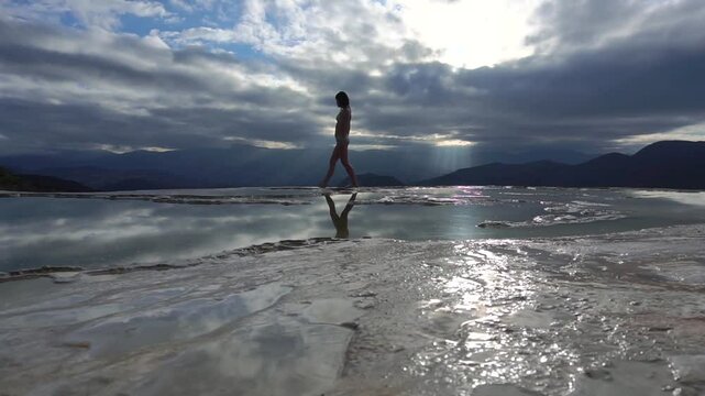 Asian Girl in Bikini is Dancing on the Edge of Natural Petrified Waterfall Hierve el Agua in Mexico, Oaxaca. Travelling.