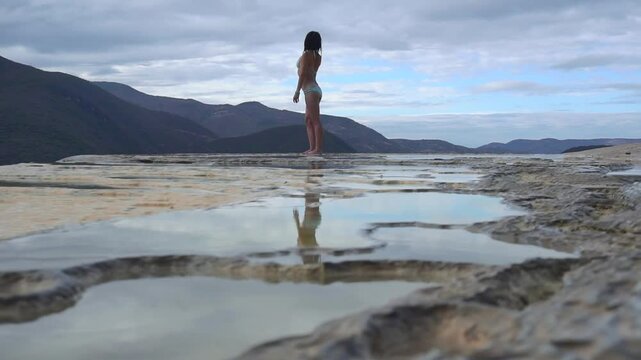 Asian Girl in Bikini is Dancing on the Edge of Natural Petrified Waterfall Hierve el Agua in Mexico, Oaxaca. Travelling.
