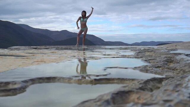 Asian Girl in Bikini is Dancing on the Edge of Natural Petrified Waterfall Hierve el Agua in Mexico, Oaxaca. Travelling.