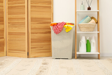 Wicker basket full of laundry, detergents and toiletries in bathroom