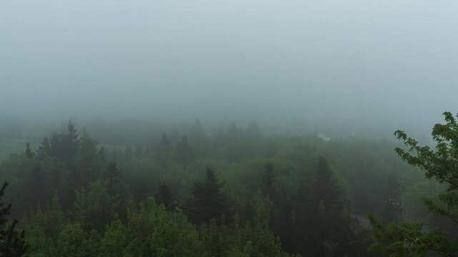 Time laps of low hanging clouds or fogg in the mountains in eastern Germany, slowly getting dark..