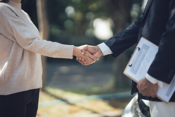 Successful Deal: A close-up shot depicts a handshake between a businesswoman and a businessman,...