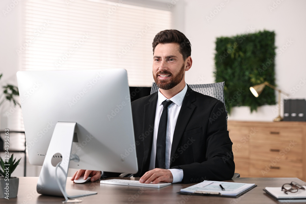 Poster man working on computer at table in office
