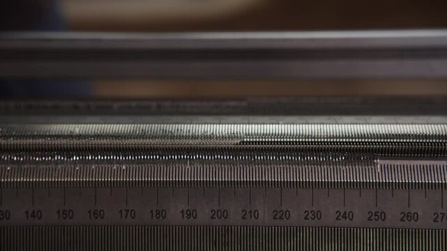 Close-Up Of Flat Bed Knitting Machine In Use
