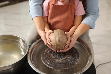 Hobby and craft. Mother with her daughter making pottery indoors, closeup