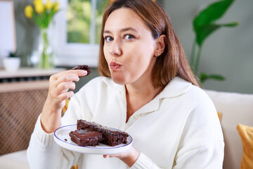 Young woman eating chocolate cake
