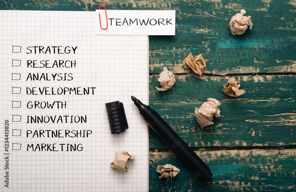 Poster piece of paper with a black marker on it with the word teamwork written in red