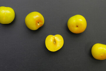 Fresh green plum fruit on dark background.