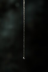 Single raindrop on a delicate spider web strand.