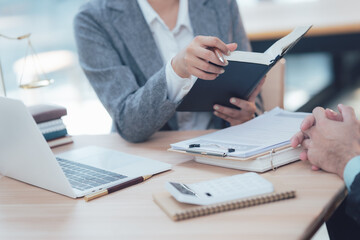 Legal Consultation: A lawyer carefully explains legal concepts to a client in a professional setting, emphasizing the importance of clarity and trust in the legal process. The image features a laptop.