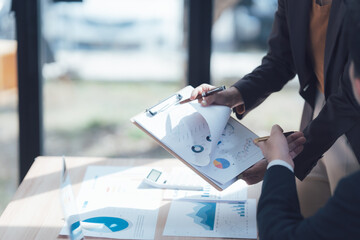 Business Analysis: Close-up of a business professional meticulously reviewing charts and graphs...